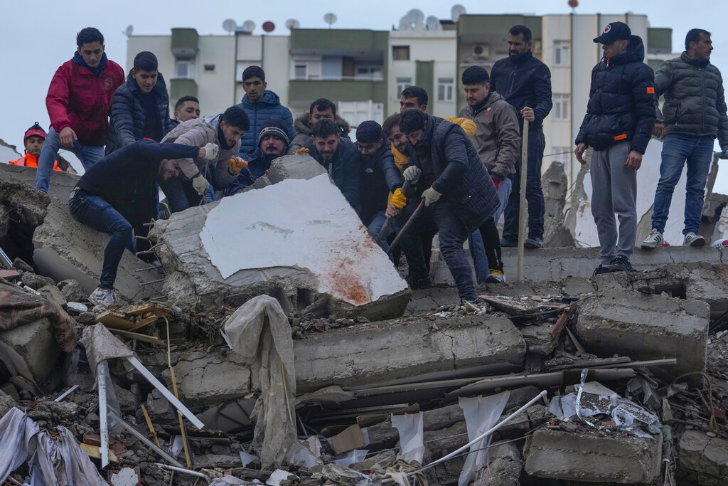 חיפושים אחר ניצולים בהריסות בבניין בעיר אדנה שבטורקיה, שקרס ברעידת האדמה (צילום: AP/Halil Hamra)