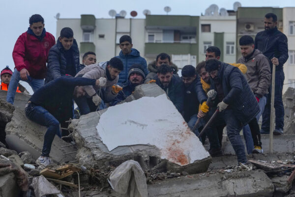 אנשים מנסים להזיז לוח בטון בניסיון למצוא אנשים באדנה, טורקיה  (צילום: AP Photo/Khalil Hamra)