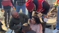 איסמאיל דינסל (יושב כשפניו למצלמה) מפדרציית המערנים הטורקית בחילוץ של נערה מבניין שנהרס ברעידת האדמה בעיר אנטקיה (צילום: פדרציילת המערנים הטורקים)