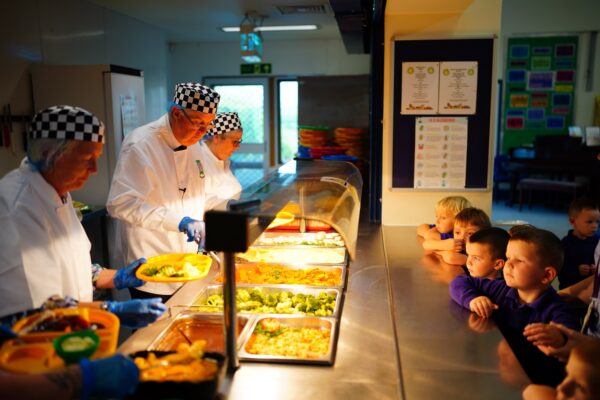 מארק דרייקפורד, ראש ממשלת וויילס מטעם ממשלת בריטניה, מגיש אוכל לילדים בתכנית ארוחה לכל ילד בבית ספר יסודי בוויילס (צילום: PA/Reuters)
