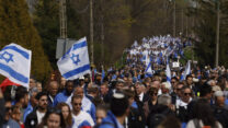 צעירים במצעד החיים בפולין, בין מחנות המוות אושוויץ לבירקנאו (AP Photo/Michal Dyjuk)