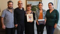 משפחת אשר. מיטל פנחס (מימין), שרון בורג, דרורה אוחזת בתמונת ראובן, רמי  וגיל (צילום: ג'וליה לרמה)