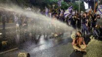 מפגינים נגד הרפורמה המשפטית חוסמים את נתיבי איילון, בזמן ששוטרים מפעילים נגדם מכונת התזה (מכת"זית) כדי לפנות אותם (צילום:  אריק מרמור / פלאש 90)