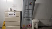 שלט הנחיות בכניסה לבית החולים בילינסון בפתח תקווה וארון חמץ (צילום: דפנה איזברוך)