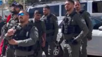 שוטרים מחרימים דגלים אדומים בפשיטה על סניף מפלגת חד"ש בנצרת (צילום מסך מסרטון שהופץ על ידי דוברות חד"ש)