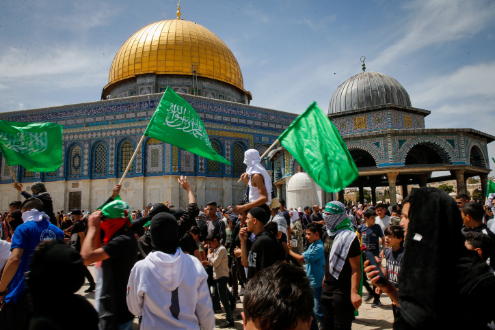 רעולי פנים מניפים דגלי חמאס במסגד אל-אקצא בירושלים (צילום: ג'מאל עוואד/פלאש90)