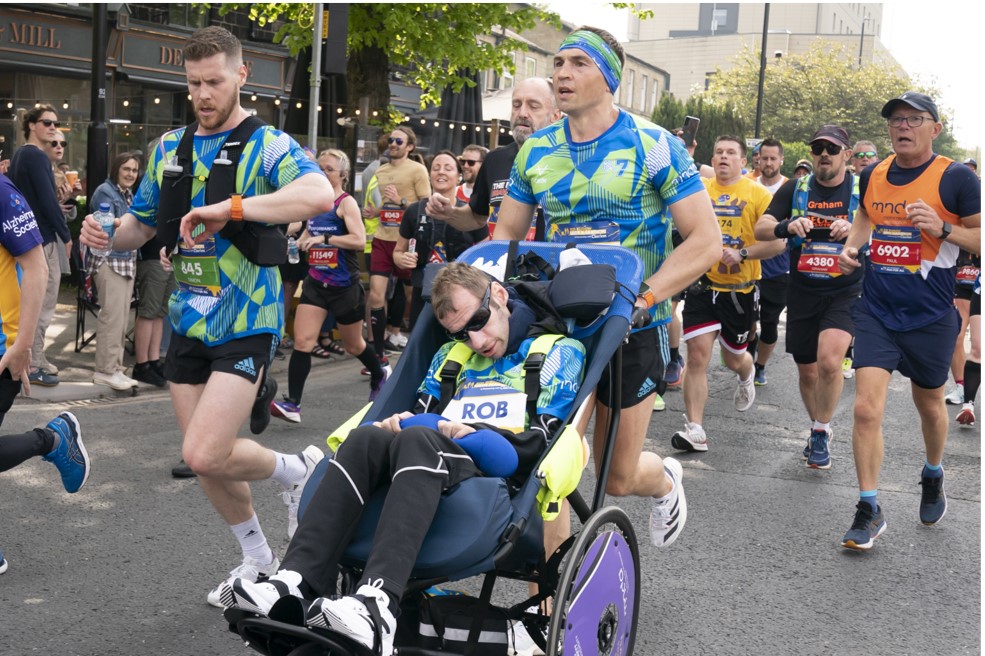 קווין סינפילד מסיע את חברו רוב בורו על כסא גלגלים, במרתון "רוב בורו" בלידס 2023 (צילום: PA Images via Reuters Connect)