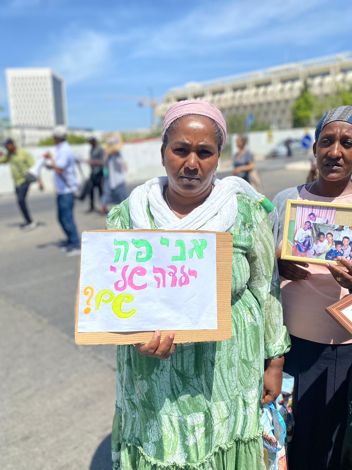Yardao, a recent olah from Ethiopia, holds a sign saying: “I’m here, my daughter’s there?” (Photo: Yahel Faraj).