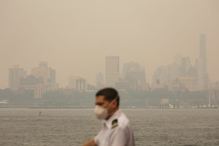 איש צוות מעבורת עם מכסה בזמן עשן על ניו יורק בעקבות שריפות בקנדה (צילום: AP Photo/Yuki Iwamura)