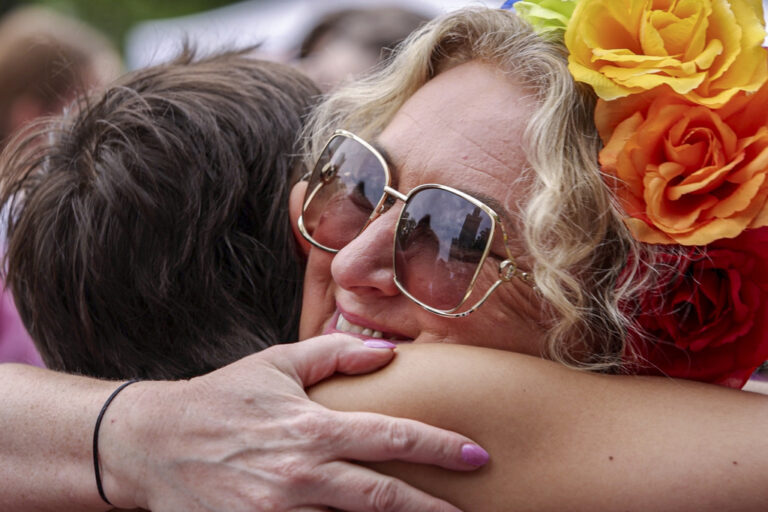 אם שמתנדבת בקבוצת &quot;אנחנו, ההורים&quot; מחבקת את אחד מהצועדים במצעד הגאווה בוורשה. &quot;כאן אתם בטוחים&quot; (צילום: AP Photo/Michal Dyjuk)