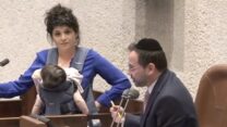ח״כ שרן השכל עם בתה התינוקת במליאת הכנסת, לאחר שהתבקשה להפסיק לנאום על ידי ממלא מקום היו״ר, ח״כ אוריאל בוסו (צילום: צילום מסך מתוך ערוץ הכנסת, שידור חי)