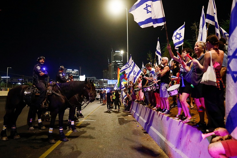מפגינים נגד הרפורמה המשפטית בנתיבי איילון בתל אביב, מול פרשים משטרתיים ( REUTERS/Corinna Kern)