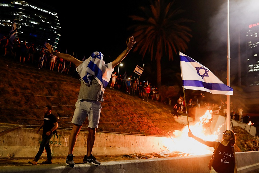 מפגינים נגד הרפורמה המשפטית מבעירים מדורות בנתיבי איילון בתל אביב ( REUTERS/Corinna Kern)