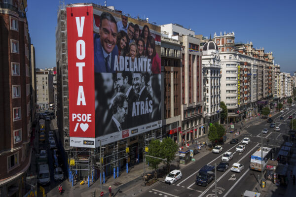 שלט תמיכה בראש הממשלה פדרו סנצ'ס במדריד. על תמונתו נכתב "קדימה", ועל תמונתם של מנהיגי הימין למטה נכתב "אחורה" (צילום: AP Photo/Manu Fernandez)