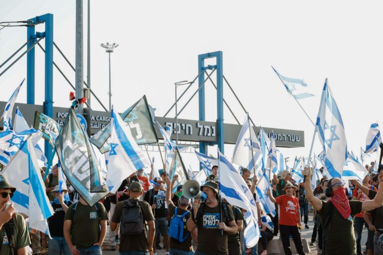 עשרות מפגינים מתנועת המחאה אחים לנשק חוסמים את כניסת המשאיות לנמל חיפה במחאה נגד הרפורמה המשפטית (צילום: גיל לוין)