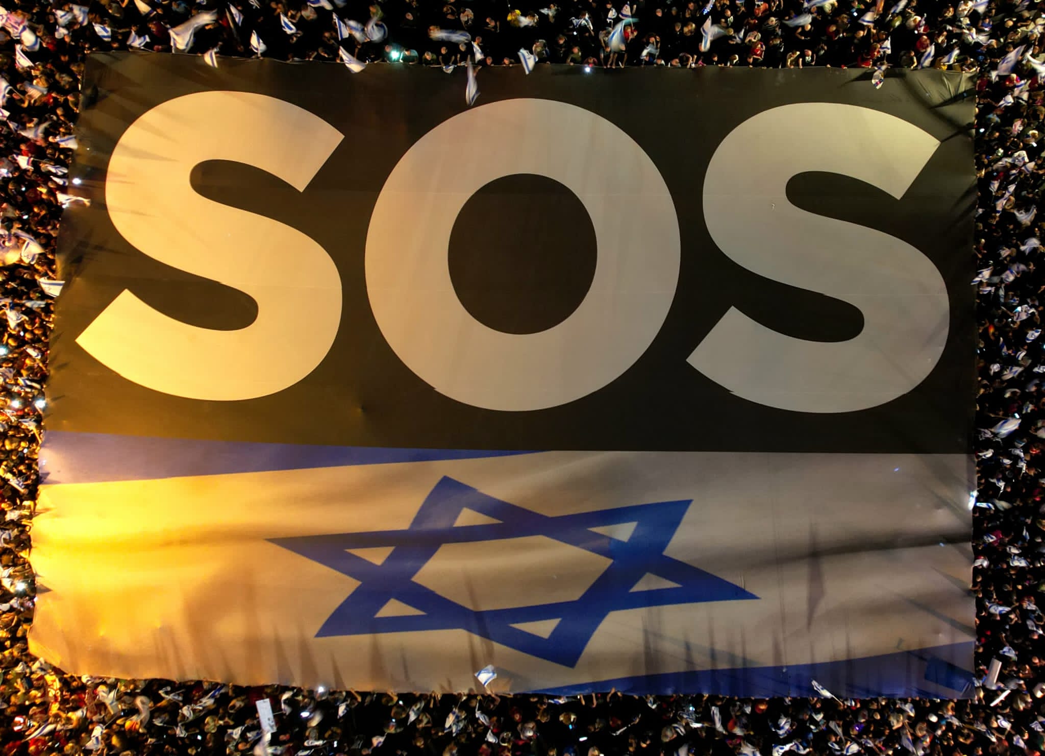 שלט 'SOS' בהפגנת מחאה נגד הרפורמה המשפטית בשדרות קפלן בתל אביב (צילום: אמיר גולדשטיין)