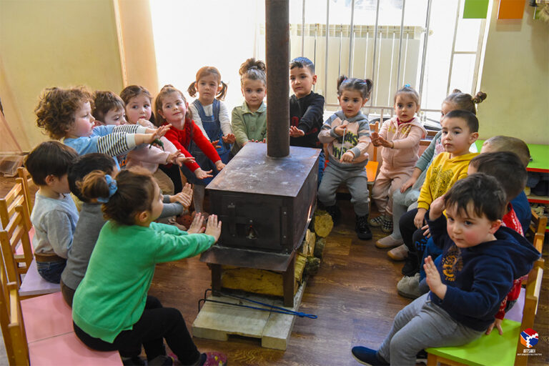 ילדים בסטפנקרט מתחממים סביב תנור הסקה לאחר שאספקת הגז הופסקה. הטמפרטורות מתחת לאפס, ואין אמצעים אחרים להתחמם בחורף (צילום: מרכז המידע של ארצאך)