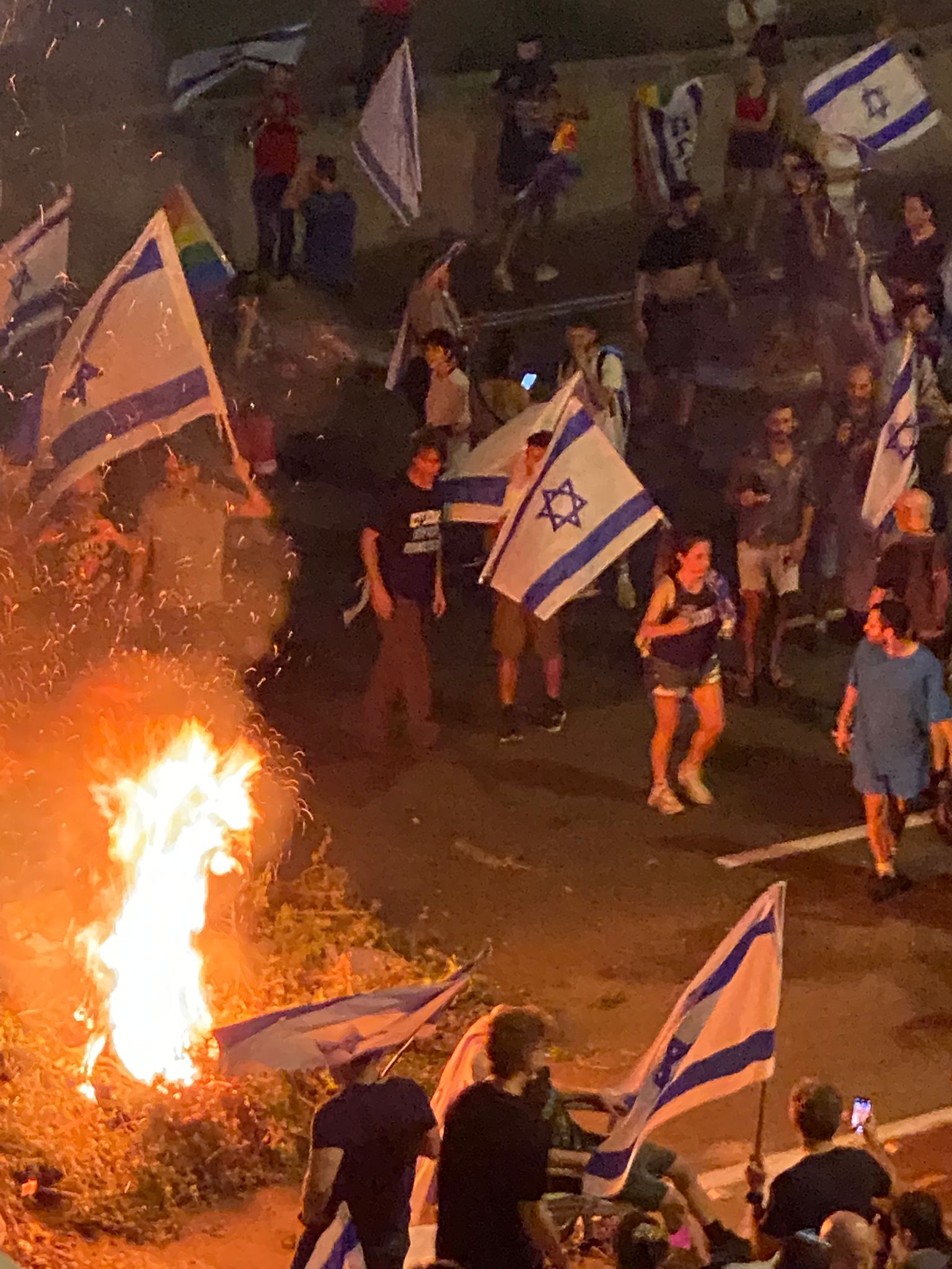 מפגינים נגד הרפורמה המשפטית מבעירים מדורות בנתיבי איילון בתל אביב, סמוך לגשר יהודית (צילום: ארגוני המחאה)