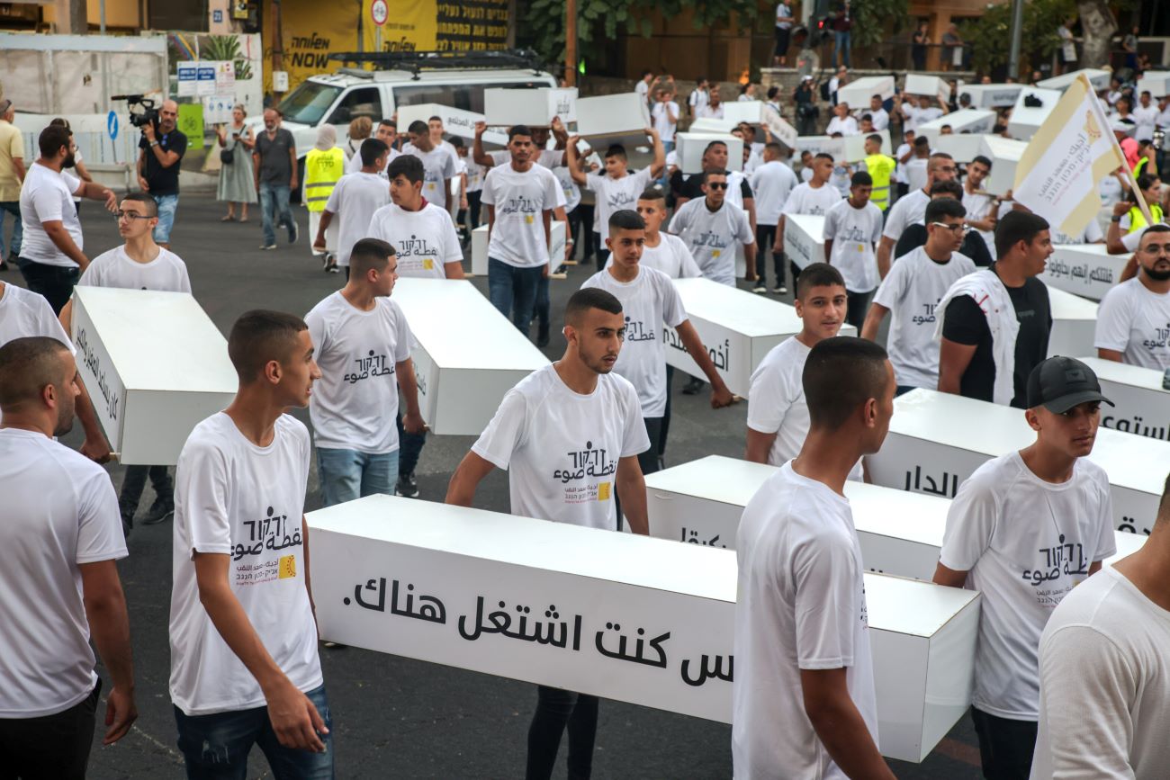 Participants wear white and carry empty white coffins at the “March of the Dead” (Photo: Kadia Levy).