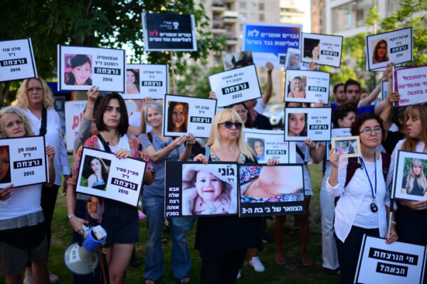 מפגינות אוחזות בתמונות נשים שנרצחו בהפגנת מחאה על אלימות כלפי נשים (צילום: תומר נויברג / פלאש 90)