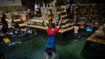 רוחצים בעין פרת בוואדי קלט (צילום: יונתן זינדל/פלאש90)