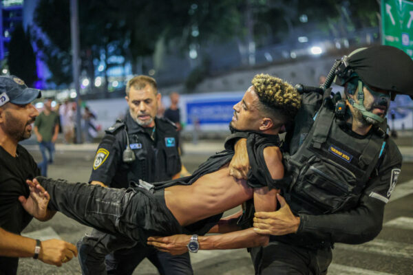 צעיר מלווה על ידי שוטרים  בהפגנה "צדק לרפאל" בתל אביב (צילום: איתי רון, פלאש90)