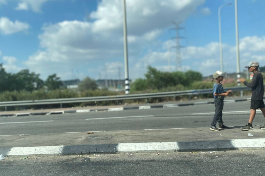 שני ילדים מקבצים נדבות בצומת אחיהוד (צילום: יהל פרג')