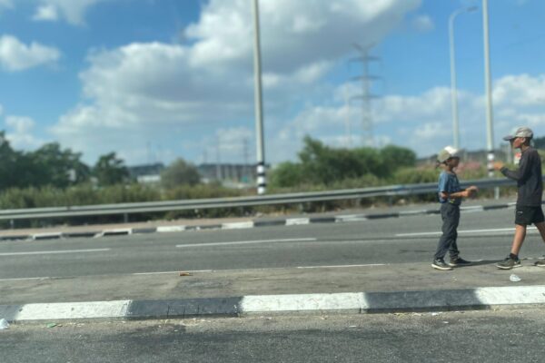 שני ילדים מקבצים נדבות בצומת אחיהוד (צילום: יהל פרג')