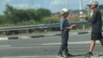 שני ילדים מקבצים נדבות בצומת אחיהוד (צילום: יהל פרג')
