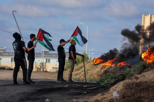 צעירים פלסטינים במהלך הפגנה לאורך גדר הגבול עם ישראל, מזרחית לעזה (צילום: עטיה מוחמד/פלאש90)