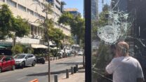 פגיעת אבנים בחלון ראווה בחנות בדרום תל אביב לאחר עימותים אלימים של יוצאי אריתריאה (צילום: אורן דגן)