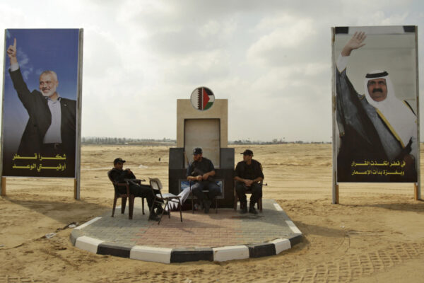 אנשי ביטחון של חמאס בחאן יונס ב-2007 בין תמונותיהם של אמיר קטאר, שייח' חאמד בן-ח'אליפה השני, ושל מנהיג חמאס בעזה דאז, איסמעיל הנייה (צילום: REUTERS/Ibraheem Abu Mustafa)