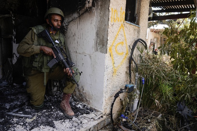 FILE - An Israeli soldier takes a position in Kibbutz Kfar Azza on Tuesday, Oct. 10, 2023. Hamas militants overran Kfar Azza on Saturday, where many Israelis were killed and taken captive. (AP Photo/Ohad Zwigenberg)