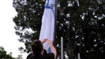 הורדת דגל ישראל לחצי התורן בקיבוץ נען (צילום: דוד טברסקי)