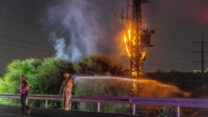 לוחמי האש מנסים לכבות עמוד חשמל ליד רמלה, במקום בו נפלה רקטה שנורתה מעזה (צילום: יוסי אלוני/פלאש90)