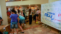 מתנדבים עם תושבי קיבוץ בארי במלון בים המלח, לאחר שפונו מבתיהם (צילום: יוסי זמיר/פלאש90)