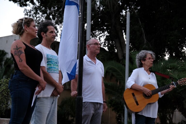 The Israeli flag was lowered to half mast in Kibbutz Na'an. From right to left: Dafna Zahavi, Ido Gorni, Asaf Gudo, and Re'ah Ben Abraham. (Photo: David Tabarsky).