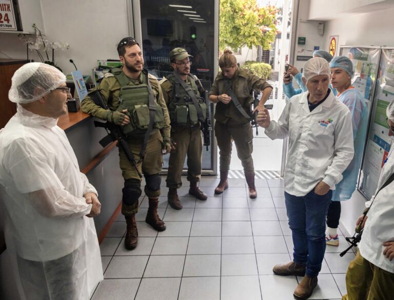 עובדים ומנהלים במפעל עם מפקד הגזרה, סא"ל טל בורשטיין (שני משמאל). "המשימה שלנו התחילה כמשימת צבאית, והפכה למשימה עם אופי היסטורי: החזרת העובדים למקומות העבודה" (צילום: כדיה לוי)