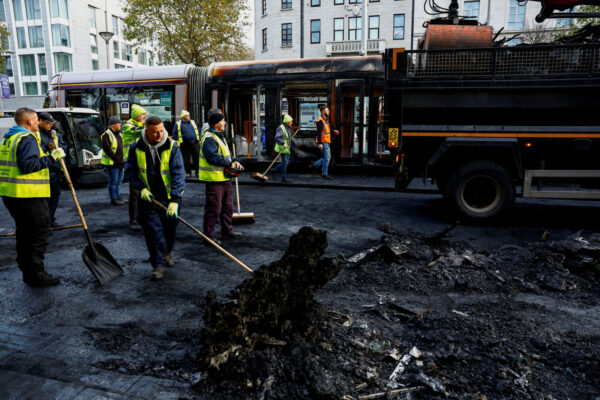 עובדים מנקים שיירי רכבים שנשרפו כליל בעקבות המהומות בדבלין, אירלנד (REUTERS/Clodagh Kilcoyne)