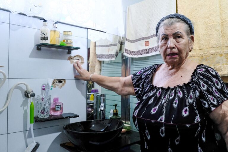 נאדז'דה אסטרקס מסמנת את חור הקליע בחדר האמבטיה בביתה (צילום: דוד טברסקי)