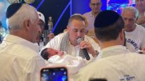 חי לוי, שפונה עם אשתו ארגמן משדרות, מחזיק את בנו הטרי רפאל בטקס ברית המילה במלון לאונרדו קלאב באילת (צילום: אלבום פרטי)