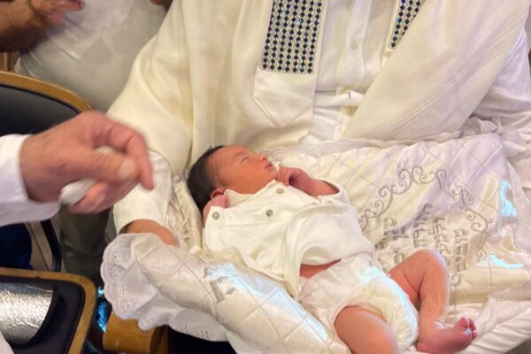 רפאל הרך הנולד בידיו של אביו חן, בטקס ברית המילה שנערך במלון ליאונרדו קלאב (צילום: אלבום פרטי)