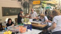 מתנדבים במסעדת פנקיטה בת"א. "עשרות אנשים מתרוצצים – חותכים ירקות, מתבלים, מבשלים פסטה בשמנת ואורז עם דלעת, מטגנים דגים בפירורי לחם" (צילום: אורן דגן)