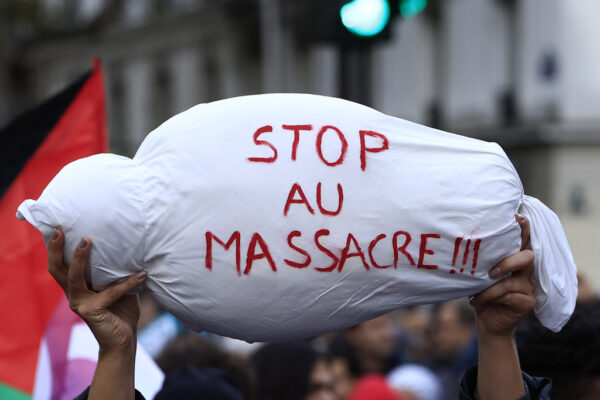מיצג של גופת ילד פלסטיני בהפגנת תמיכה בתושבי עזה שהתקיימה בפריז ב-4 בנובמבר, המיצג נושא את הכיתוב "הפסיקו את הטבח" (AP Photo/Aurelien Morissard)