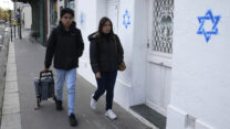 תושבים ברחוב לצד בתים שסומנו במגן דוד בפריז, צרפת (צילום: AP Photo/Michel Euler, Pool)