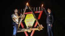 בועז צברי (משמאל) מדליק נר ראשון של חנוכה בתחנת מד"א בשדרות, יחד עם מנהל המרחב במד"א חיים קרדי (צילום: כדיה לוי)