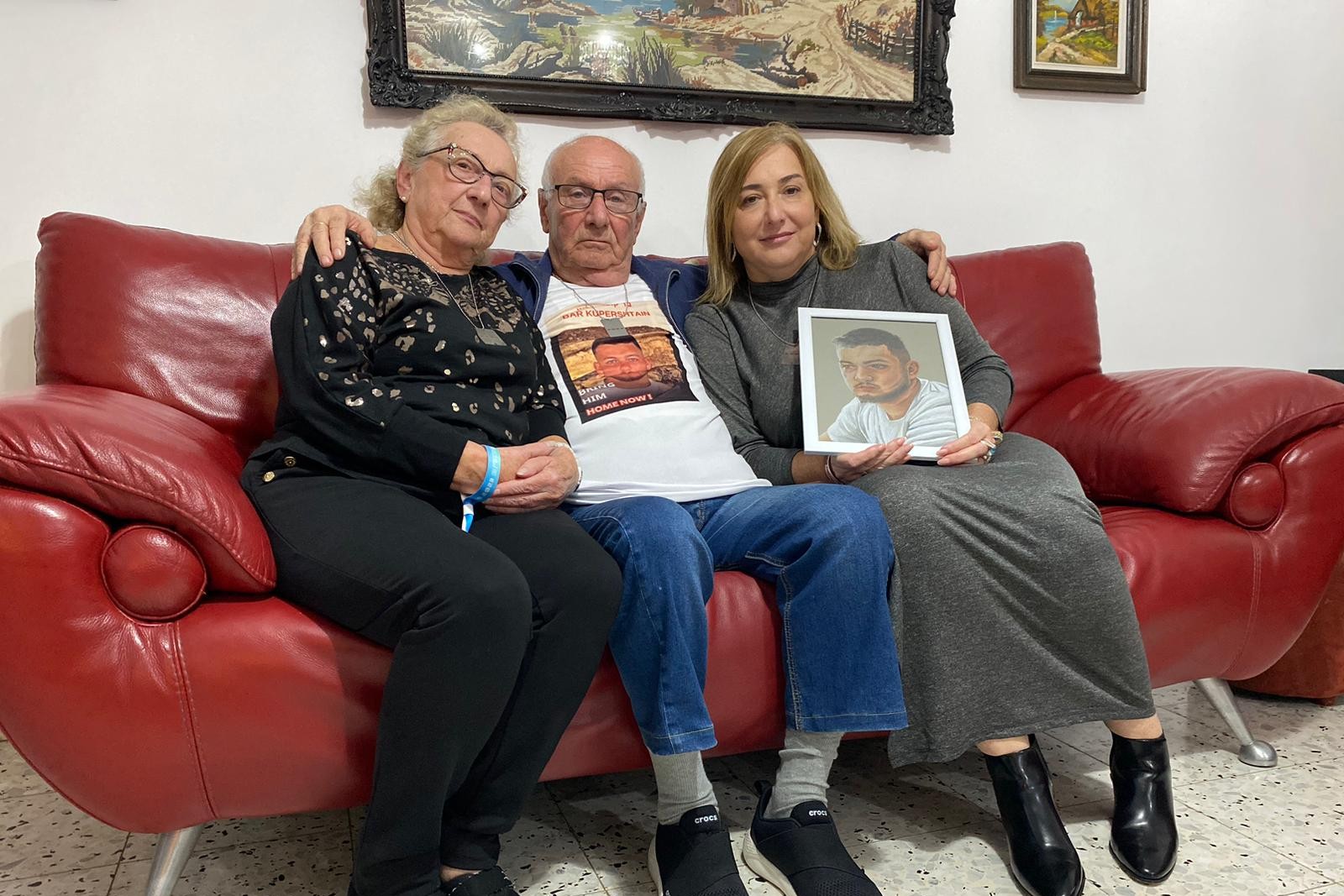פאינה ומיכאל קופרשטיין, סבתא וסבא של בר קופרשטיין החטוף, עם בתם אורה רובינשטיין, הדודה שאוחזת את תמונתו (צילום: יהל פרג')