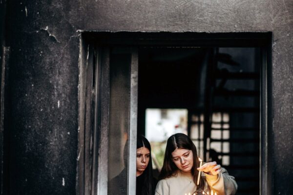 נגה וייס ששוחרה משבי חמאס מבקרת לראשונה בביתה ההרוס בבארי בזמן חנוכה, מדליקה נר שמיני עם אחותה מיטל (צילום: מיכה בריקמן)