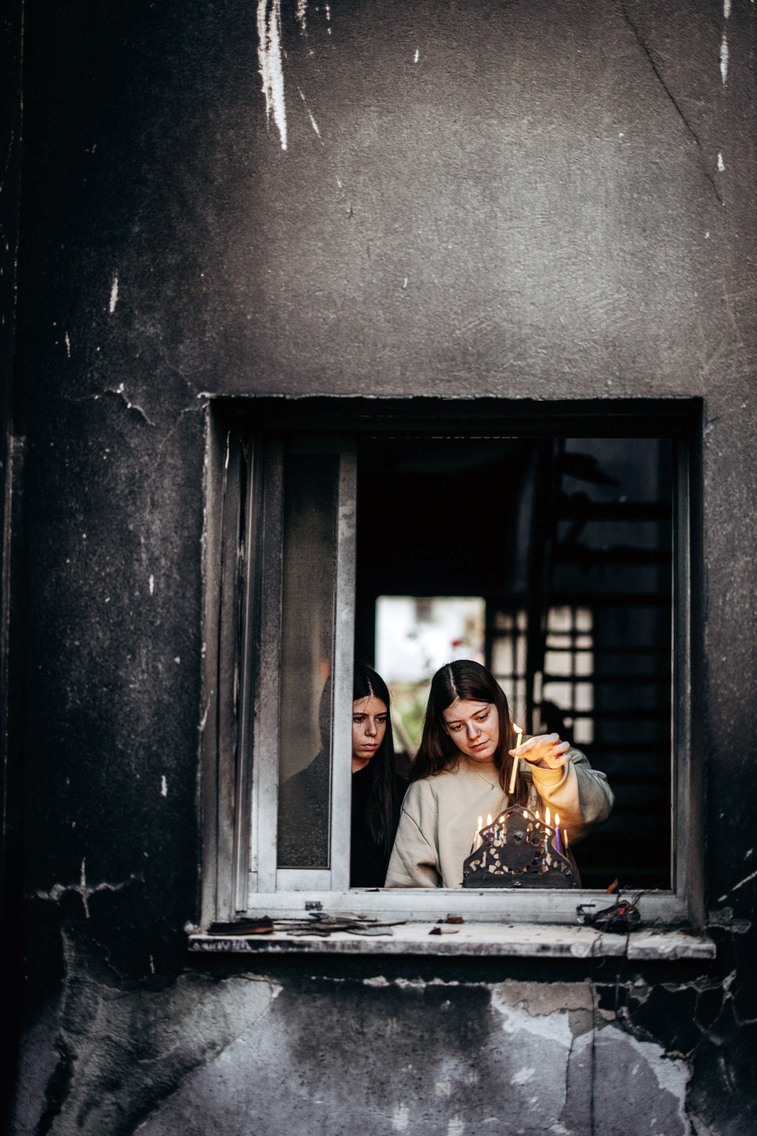 נגה וייס לאחר ששוחררה משבי חמאס, בהדלקת נר שמיני עם אחותה מיטל, בביקור ראשון בביתה ההרוס בבארי (צילום: מיכה בריקמן)