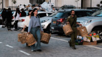 מתנדבים בקריית גת סוחבים ציוד עבור מפוני ניר עוז (צילום: דוד טברסקי)
